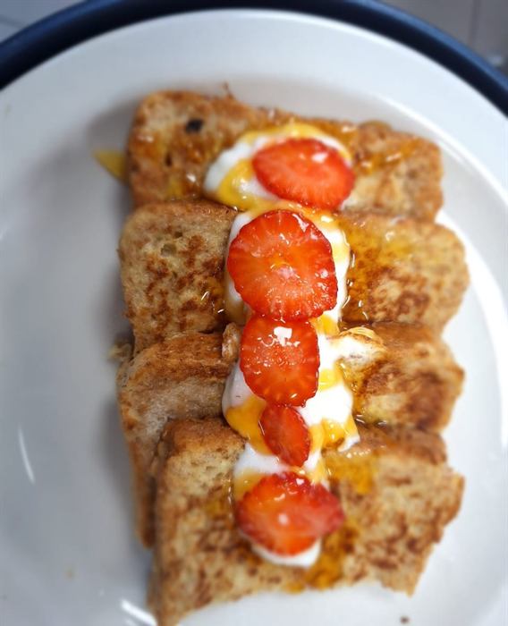 Slices of French toast layered with cream and fresh strawberries