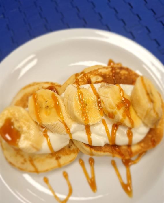 Pancakes fanned out with banana slices and caramel