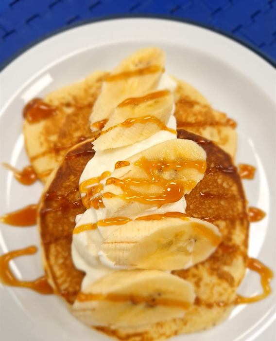 Pancake with cream, banana and a caramel drizzle