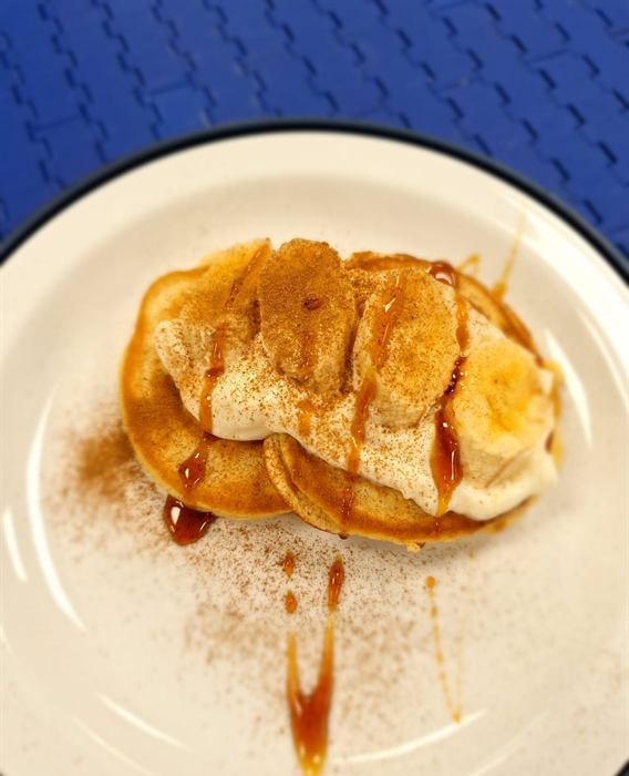 Pancakes with banana, dusted with cinnamon and finished with caramel