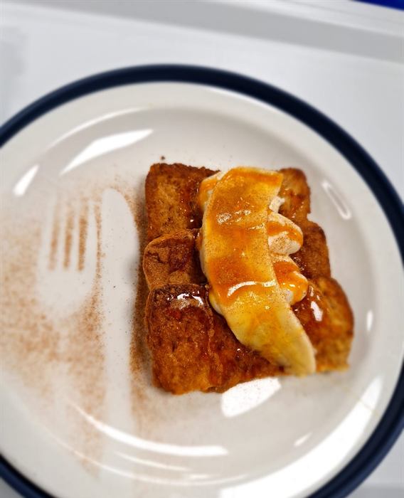 French toast with banana and caramel, dusted with cinnamon
