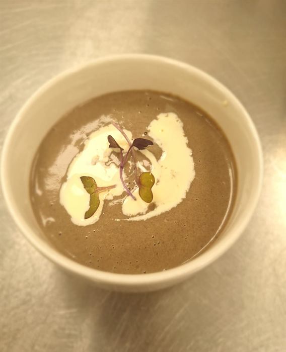 Mushroom soup finished with cream and a scattering of herbs
