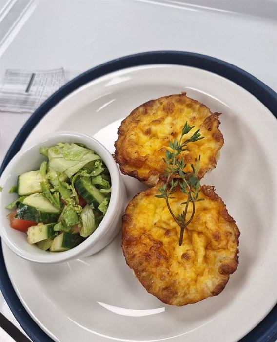 Golden potato fritters with rosemary beside a cucumber and herb salad