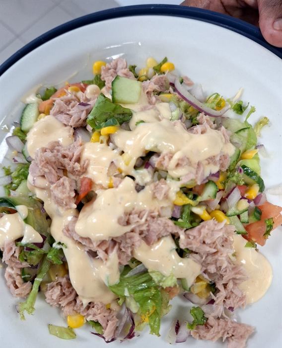 Tuna salad over leaves with sweetcorn, tomato and a mayonnaise dressing