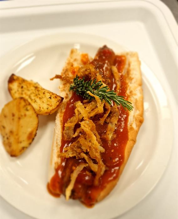 Barbecue-glazed rib under a tangle of crisp fried onion and rosemary, with roast potato wedges