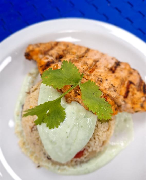 Grilled chicken breast on herbed couscous with a green herb puree and fresh coriander