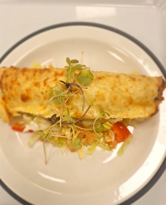 Folded omelette filled with tomato and pepper, dressed with micro herbs