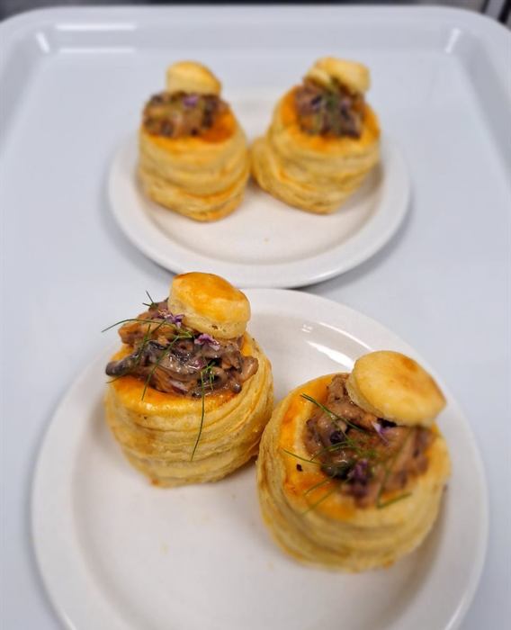 Two puff-pastry vol-au-vents filled with a dark mushroom ragout