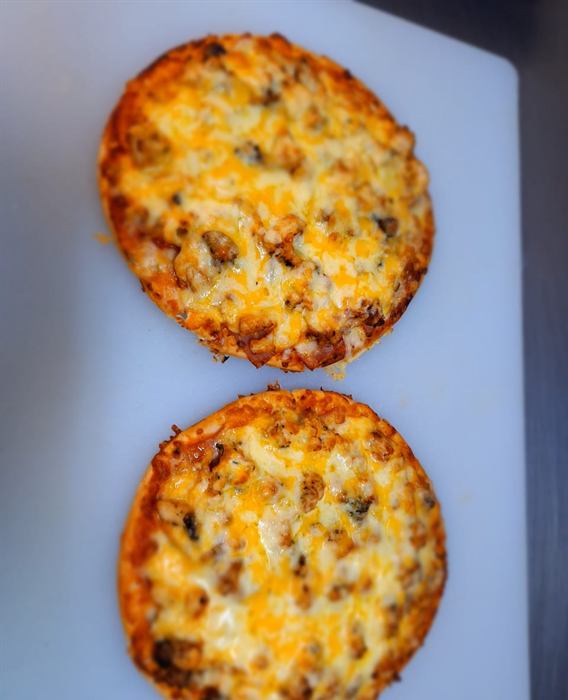 Two baked cheese-topped tartlets straight off the tray