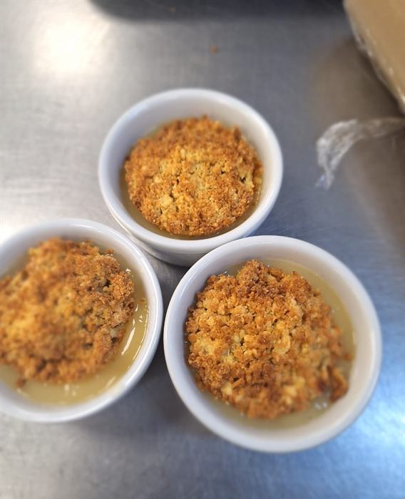 Crumble portions in ramekins sitting in custard