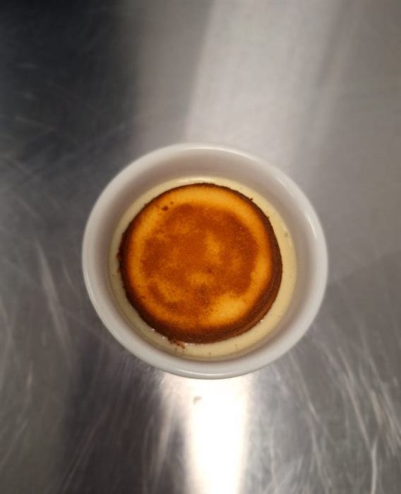 A baked custard tart in a white ramekin