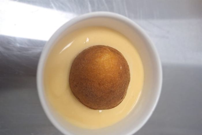 A sponge pudding in custard, shot from above