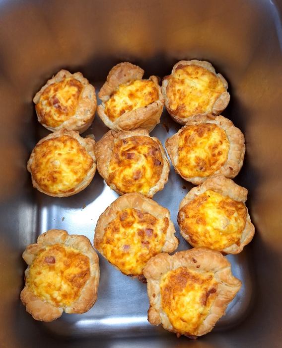 A tray of baked cheese tartlets straight from the oven